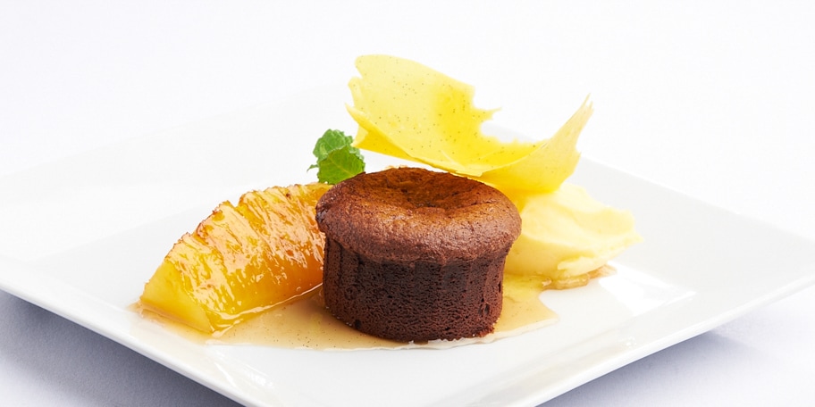 Warme chocolademoelleux, gemarineerde ananas met kruiden en sinaasappelsorbet