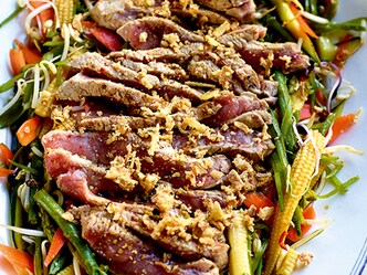 Salade aigre-douce piquante aux tranches de bœuf juste saisies, à la sauce soja et au sésame grillé