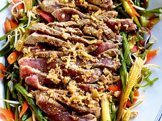 Pittige zoetzure salade met gekorste runderlapjes, sojasaus en geroosterde sesam
