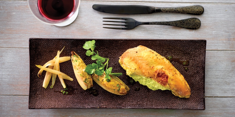 Volaille farcie au beurre d’herbes sous la peau, servie avec des chicons farcis