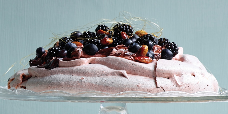 Pavlova met pure chocolade, gekarameliseerde amandelen, bramen en blauwe bosbessen
