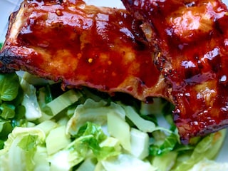 Gemarineerde en gekarameliseerde spareribs, gebakken bloemkoolstengels met look