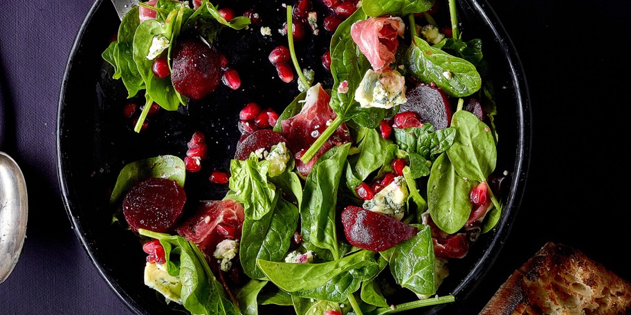 Salade met granaatappel, stiltonkaas, spinazie en Ibericoham