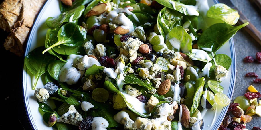 Salade de jeunes feuilles d'épinards aux raisins, au fromage bleu et au mélange de noix grillées