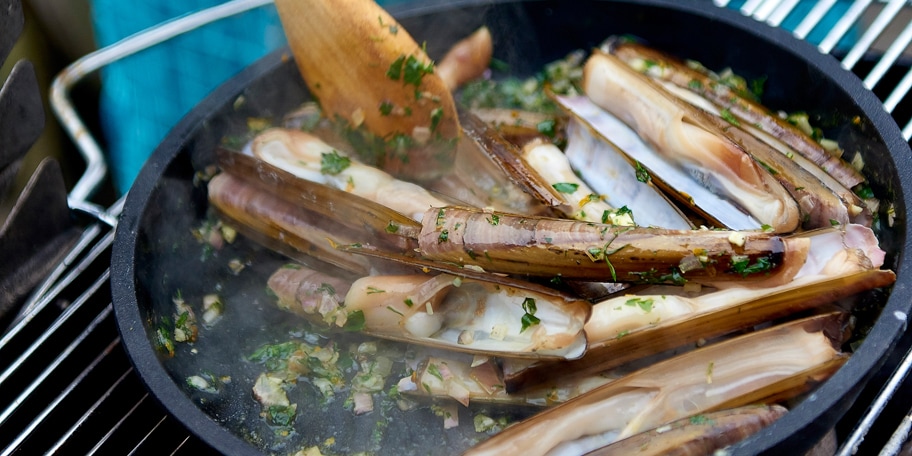 Scheermesjes op de barbecue met pittige sinaasappelkruidenboter