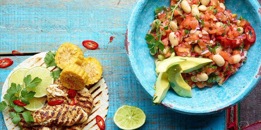 Poulet avec une salade épicée de tomates et haricots blancs