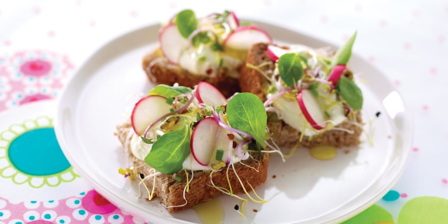 Boterham met verse kaas, radijs, mengeling scheuten en veldsla