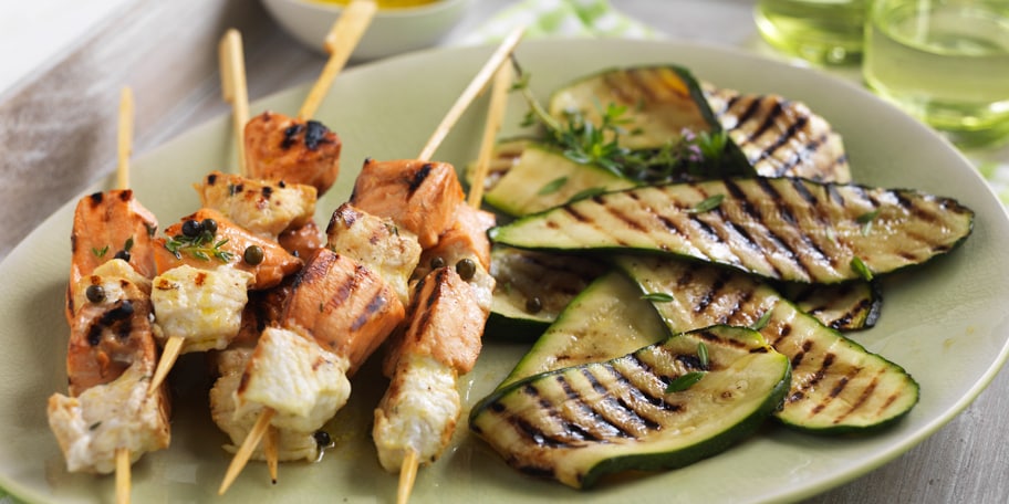 Brochettes van gemarineerde vis met gegrilde courgettes