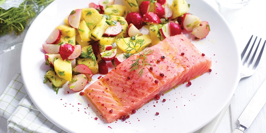 Steak van gemarineerde rauwe zalm, aardappelen en verse kruiden