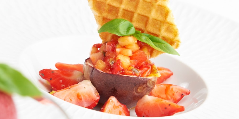Aardbeien van Hoogstraten gemarineerd met lime en basilicum, fruittartaar met citroenpeper, rodevruchtensorbet met cava en violettes