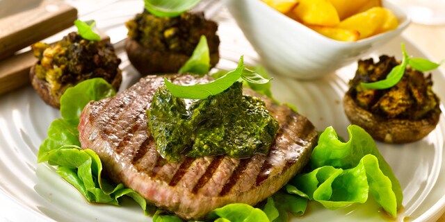 Steaks en met pesto gevulde champignons