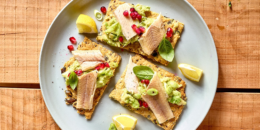 Crackers met zaadjes, gerookte forel en avocado