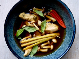 Poulet poché cuit dans un bouillon asiatique