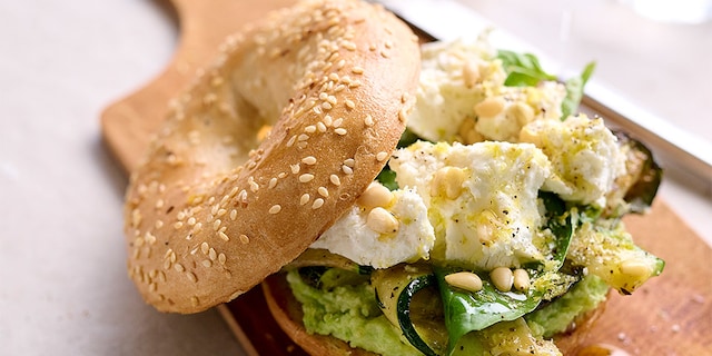 Bagel au pesto d'edamame avec courgette grillée et chèvre frais