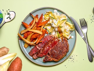 Ierse entrecote met zoete aardappel- en peterseliewortelfrietjes, witloofsalade met yoghurt