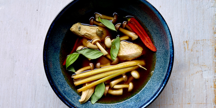 Poulet poché cuit dans un bouillon asiatique