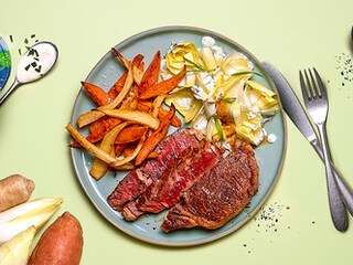 Entrecôte irlandaise aux frites de patates douces et de racines de persil, salade de chicons au yaourt