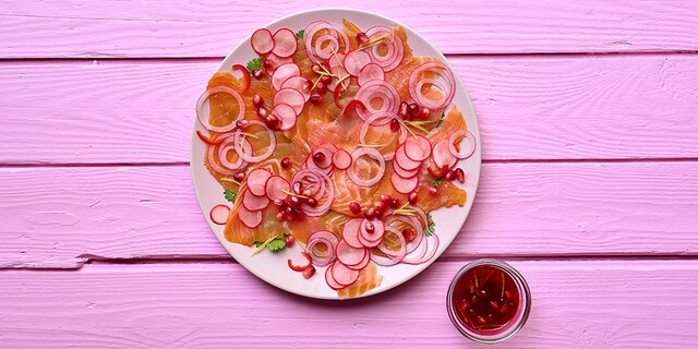Carpaccio met duo van zalm, roze pickles en granaatappelvinaigrette