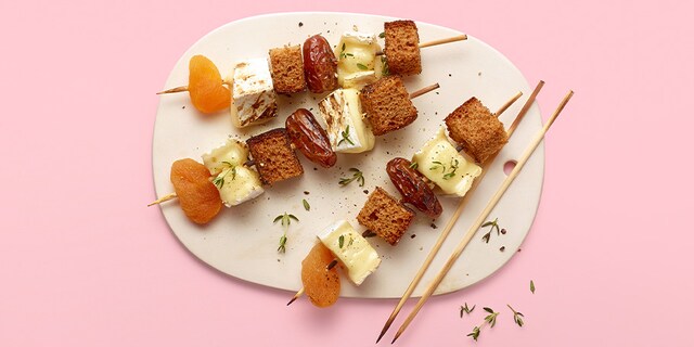 Brochette de brie fondu, pain d’épices, dattes et abricots secs