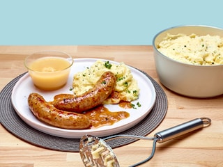 Saucisses aux oignons, compote et purée à la crème