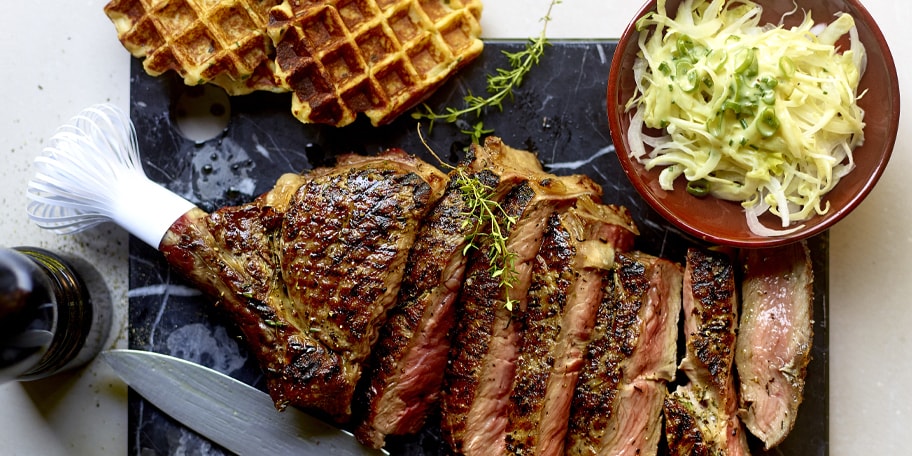 Côte à l'os bleu belge, salade de chicons et gaufres aux bintjes