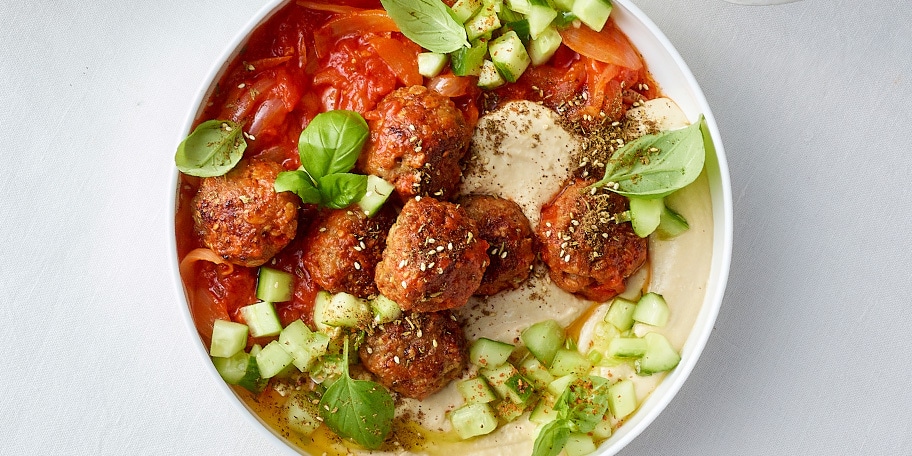 Haver-gehaktballetjes met tomatensaus, romige hummus en komkommersalade