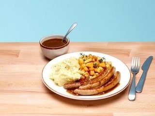 Chipolatas aux oignons, purée et dés de panais rôtis