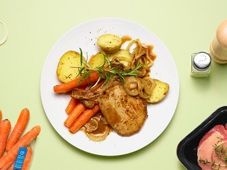 Varkenskoteletten met ajuin, geroosterde aardappelen en wortelen