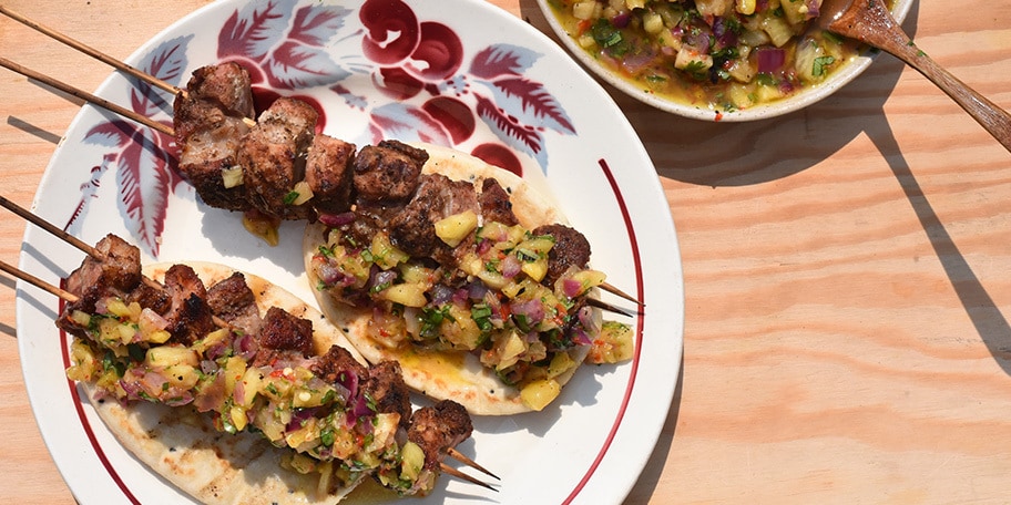 Varkensbrochettes op naanbrood en gegrilde ananassalsa