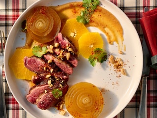 Eendenborstfilets, misosaus met sinaasappel, pinda's en goudbruine uien