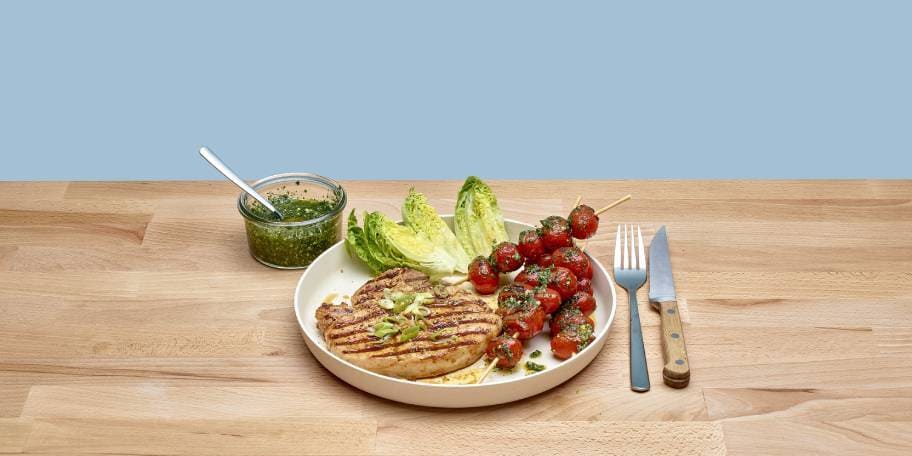 Gegrilde varkenskotelet en tomatenspiesjes met verse pesto