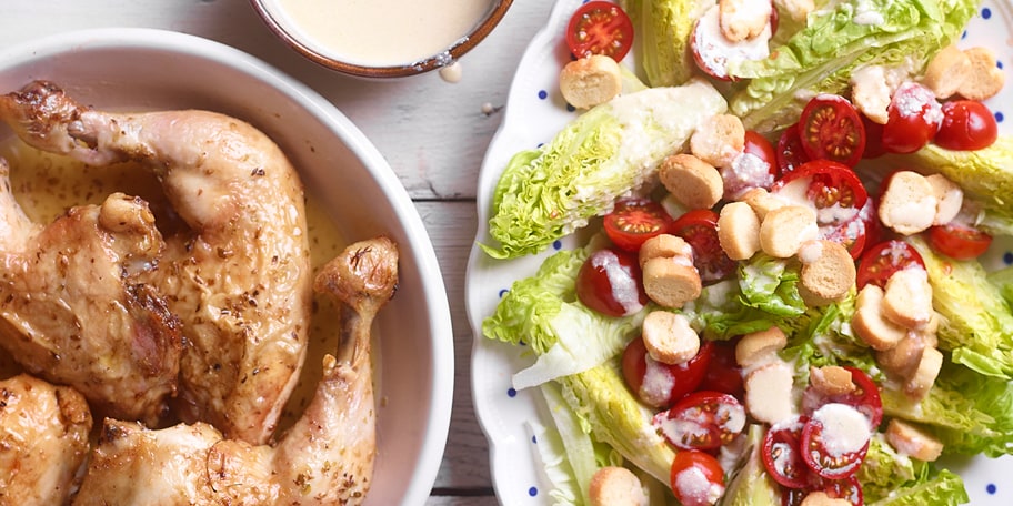In de oven gebakken kippenbouten met oregano en salade op Caesar-wijze