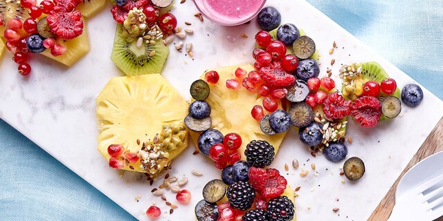 Fruitsalade met kokosmelk, zaden en een sausje van bessen