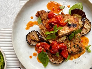 Gegratineerde kalfslapjes parmigiana met kerstomaatjes, aubergine en mozzarella