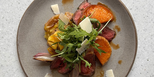 Tagliata van rundvlees, gebraden pompoen, rucola en parmigiano