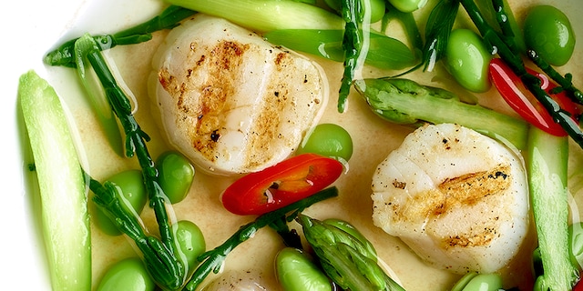 Sint-jakobsvruchten in nage van tuinkruiden en asperges