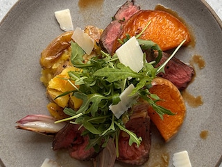 Tagliata van rundvlees, gebraden pompoen, rucola en parmigiano