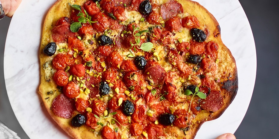 Pizza met datterinotomaten, gorgonzola en pistachenoten