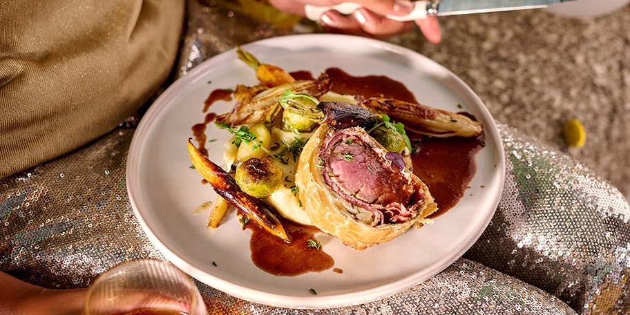 Rôti de cerf en croûte, sauce au porto et légumes rôtis