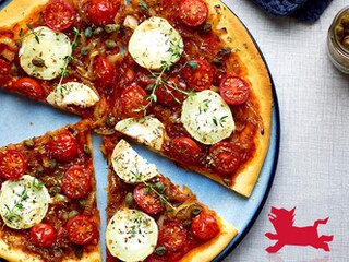 Pizza met geitenkaas, gekaramelliseerde uien en kerstomaten
