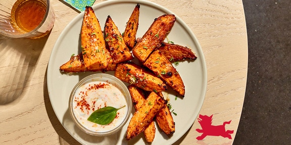 Gelakte zoete aardappelwedges met yoghurtsaus
