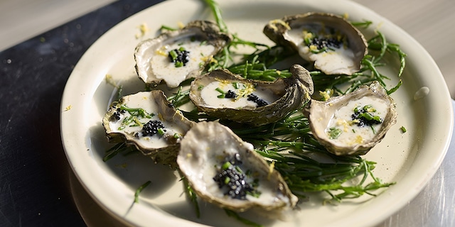 Gerookte oesters op de barbecue met sjalot-dragon saus