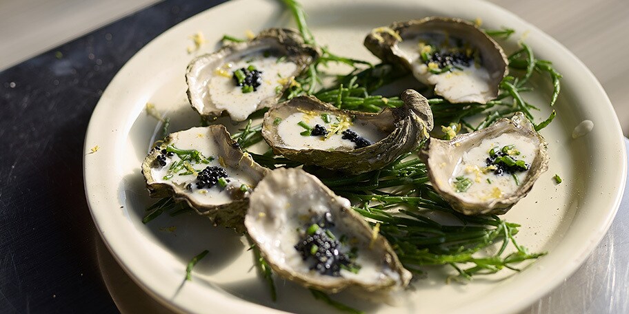 Gerookte oesters op de barbecue met sjalot-dragon saus