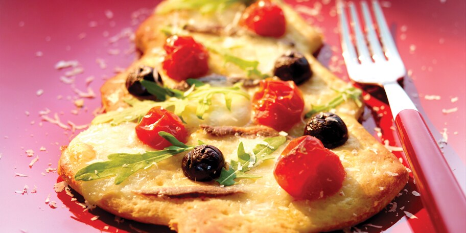 Pizza in de vorm van een kerstboom met zwarte olijven kerstomaten en mozzarellaparels