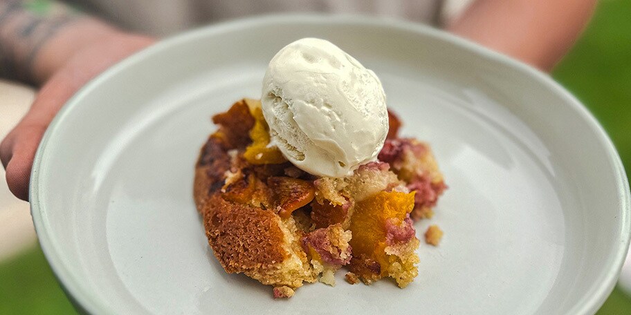Cobbler met perziken en aardbeien op de barbecue