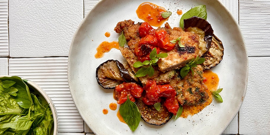 Gegratineerde kalfslapjes parmigiana met kerstomaatjes, aubergine en mozzarella