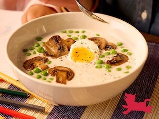 Gezouten porridge met zachtgekookte eieren, kaas, champignons en erwtjes